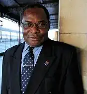 Severo Moto in Toledo, Spanien 2008. Ein afrikanischer Mann mit Brille im dunklen Anzug.