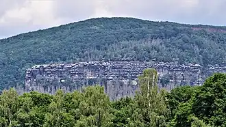 Blick von Janov u Hřenska zum Großen Winterberg, die Basaltkuppe erhebt sich über den Sandsteinfelsen der Stříbrné stěny (Silberwand)