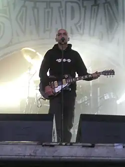 Bild eines Mannes mit Gitarre auf einer Bühne