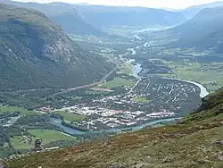 Luftbild eines sich durch ein Tal ziehenden Flusses mit einer Ortschaft an seinem Ufer