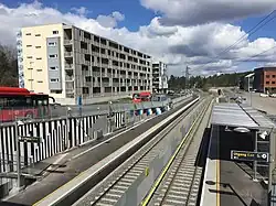 Foto von Gleisen, daneben ein Wohnblock