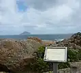 Schild. Am Horizont die 10&nbsp;km entfernte, bereits zum Bundesstaat Tasmanien gehörige Rodondo Island
