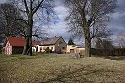 Platz des Dorfgerichts bzw. der Bauernversammlung (baumumstandener Kreis mit Mahlstein im Mittelpunkt)