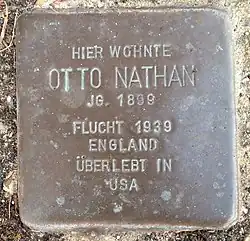 Inschrift HIER WOHNTE OTTO NATHAN JG. 1899 FLUCHT 1939 ENGLAND ÜBERLEBT IN USA, mehrzeilig.
