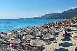 Sonnenliegen und Sonnenschirme am Strand von Borsh