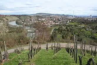 Blick vom Schnarrenberg auf Stuttgart-Münster mit über den Neckar führender Aubrücke (L&nbsp;100), Schornstein des Kraftwerks Stuttgart-Münster, links daneben befindlichem Schurwald und rechts daneben am Horizont befindlicher Schwäbischer Alb