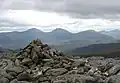 Der Gipfelcairn des Cona’ Mheall, im Hintergrund die Fannichs mit dem Sgùrr Mòr (links) und dem Sgùrr nan Clach Geala (rechts)