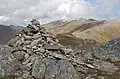 Der Gipfelcairn des An Socach, im Hintergrund Mam Sodhail und Càrn Eighe