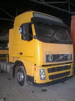 Photo einer abgestellten Sattelzugmaschine, an der vorne eine Plakette mit der Aufschrift „3“ für „EURO3 sicheres“ Fahrzeug und eine Tafel mit dem Buchstaben L angebracht ist.