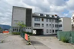 Verwaltungsgebäude mit Durchfahrt und Erweiterungsbau (links)