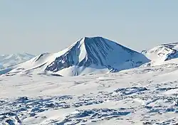 Ein pyramidenförmiger Berg, weitgehend von Schnee bedeckt