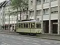 Der historische Credé-Triebwagen (Tw) 113,[8] ein Museumswagen der Braunschweiger Straßenbahn, im Jahr 2009 auf inzwischen an die östliche Straßenseite verlegten Gleisen in Höhe des ehemaligen Standortes des Alten Ministeriums, der inzwischen mit, der Unterbringung von Dienststellen der Stadtverwaltung dienenden,[3] neuem Gebäude Nr. 52 überbaut ist.