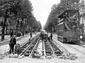 Einbau von Gleisen mit verdeckten Stromschienen in der Avenue d’Antin, rechts ein Druckluft­wagen des Systems Mékarski