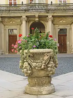 Vase mit Blumenkranz