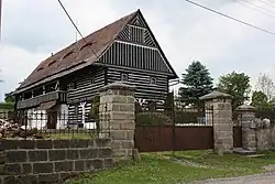 Blockbau im Obergeschoss, geschmückt durch farbliche Absetzung