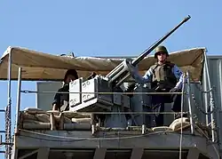 Besatzungsmitglieder an einer der beiden MK-38 Maschinenkanonen