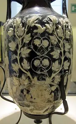 Seite mit der Frauen- und der Silenmaske. Letztere mit den sichtbaren Bruchstellen