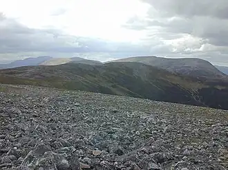 Blick vom Ostgipfel des An Socach nach Südwesten entlang des breiten Gipfelgrats zum Hauptgipfel, im Hintergrund der Beinn Iutharn Mhòr