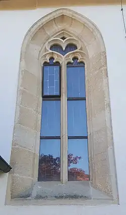 Spätgotisches Maßwerkfenster an der Nordfassade mit zwei Nonnenköpfen und Herz