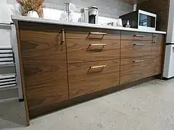 Das amerikanische Unter­nehmen SemiHandmade produziert für Sektion passende Fronten mit kostbarem Aussehen (hier: Walnuss-Furnier).