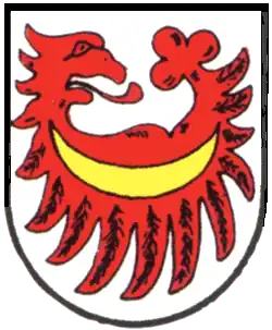 Auf großen Federn nach unten gekehrter querliegender Adlerflug, mit nach links gekehrten Adlerkopf und hinten mit Kleeblatt (Heinsheim)