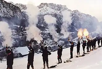 Götschener Weihnachtsschützen bei einer Salve zum Christkindl-Anschießen am Heiligen Abend über der Pfarrkirche St. Nikolaus