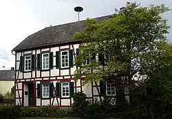 Ehemalige Schule aus der ersten Hälfte des 19. Jahrhunderts, ein Fachwerkbau mit Krüppelwalmdach