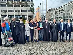 Vertreter von sieben Religionsgemeinschaften bei der Enthüllung der Friedenstaube vor dem Neuen Rathaus in Linz.