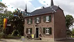 Wohnhaus (18. Jh.) in Neukirchen, im Hintergrund Pfarrkirche St. Jakobus der Ältere (1844)