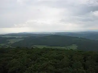 Blick vom Aussichtsturm Pferdskopf zum Wolfsküppel (mittig) im Östlichen Hintertaunus –&nbsp;mit Dorf Riedelbach (links)