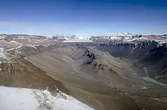 Der Dais (Bildmitte) im Wright&nbsp;Valley mit dem westlichen Ausläufer des Vandasees (rechts) und dem Oberen Wright-Gletscher (Hintergrund)