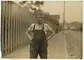 Junge in Latzhose in der Textilindustrie (Fall River, Massachusetts, 1916)