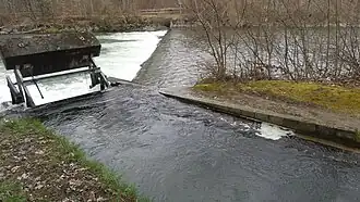 Ende des Mülibachs: fliesst mehrheitlich in einem Düker (Bodenrohr unter der Flussschwelle) unter der Emme hindurch und auf der anderen Seite weiter als Grüttbach