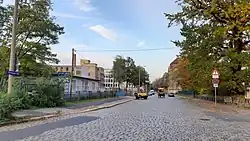 Gepflasterte Straße, in der Mitte eine Pferdekutsche, aber moderne Aufnahme