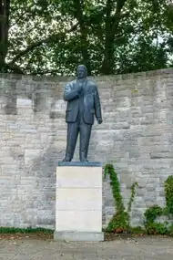 Auf einem Sockel aus drei gleich hohen Steinen steht das aus Bronze hergestellte, überlebensgroße Standbild Ernst Thälmanns.