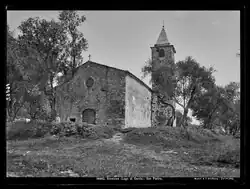 Schwarz-weiß Fotografie einer steinernen Kirche mit schlankem spitzem Kirchturm