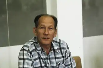 Radiosprecher Ueli Beck in kariertem Hemd, Blick in die Kamera, Brustporträt farbig, Querformat